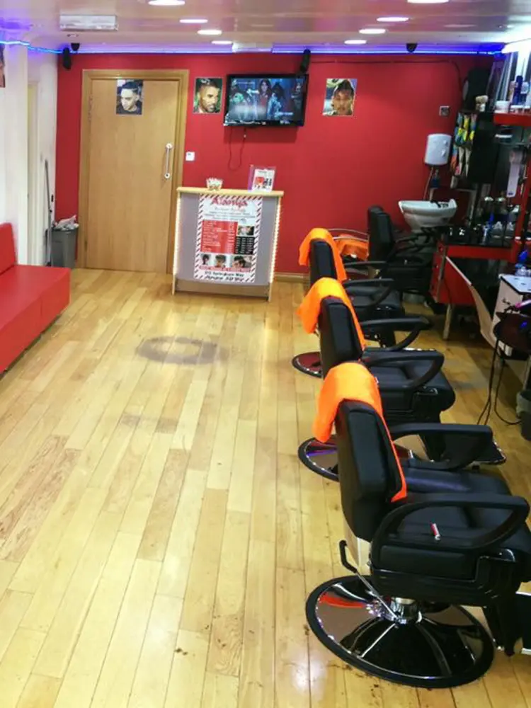Row of barber chairs against the red wall